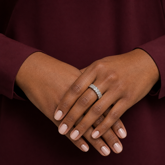 Top-down hand detail of a silver-tone adjustable pavé ring with mixed-size clear cubic zirconia.