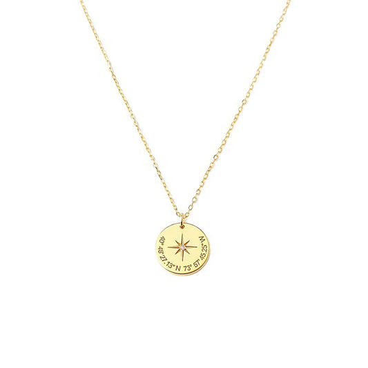 Gold-tone compass star pendant necklace with coordinate-style markings on a white background.