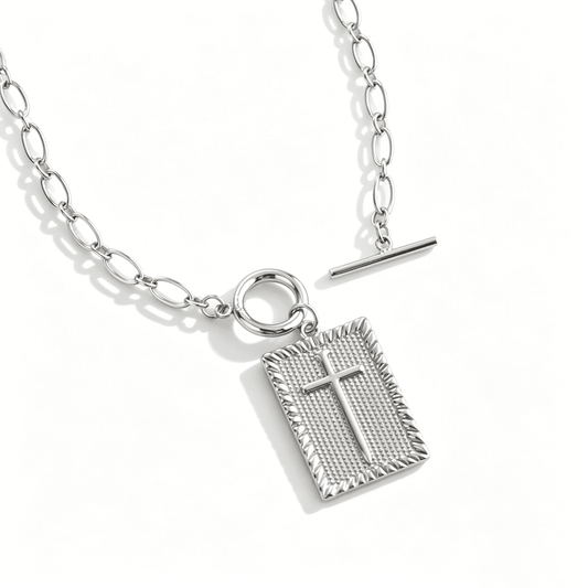 Overhead view of a silver cross necklace for women featuring a 3D geometric cube pendant.