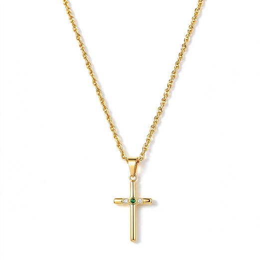 Gold-tone cross pendant necklace with a small green center accent and clear decorative details on a white background.