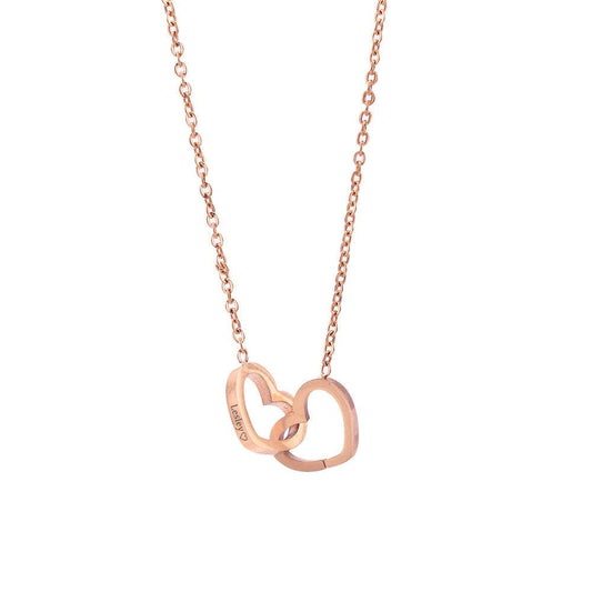 Angled close-up of gold-tone double heart necklace with name engraving and interlinked construction.
