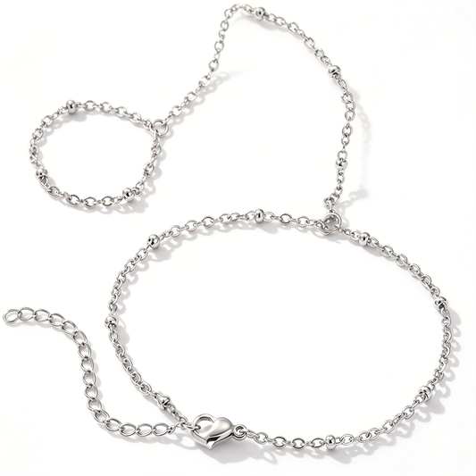 Silver-tone chain hand bracelet with a heart charm and small round bead accents displayed on a white background.