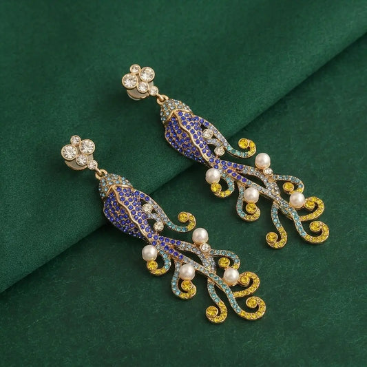 Close-up of the blue and yellow ombre crystal pave on the 18K gold plated fish earrings.