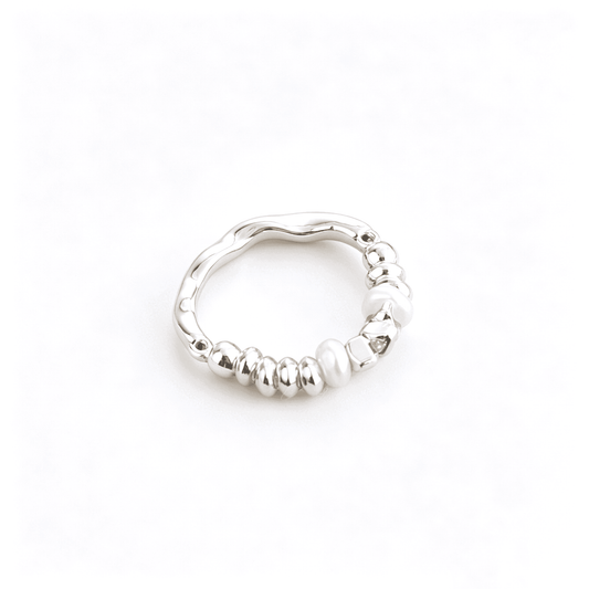 Front aesthetic view of Ever P. irregular baroque pearl ring with a molten textured chunky gold band.