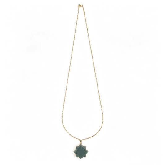 Hand-held view showcasing the opaque pastel green hues of the flower necklace under natural sunlight.