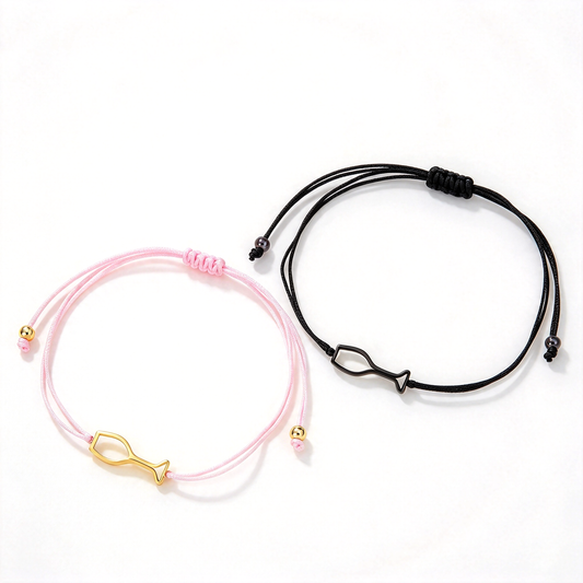 Fish charm adjustable cord bracelets in pink and black displayed together on a white background.