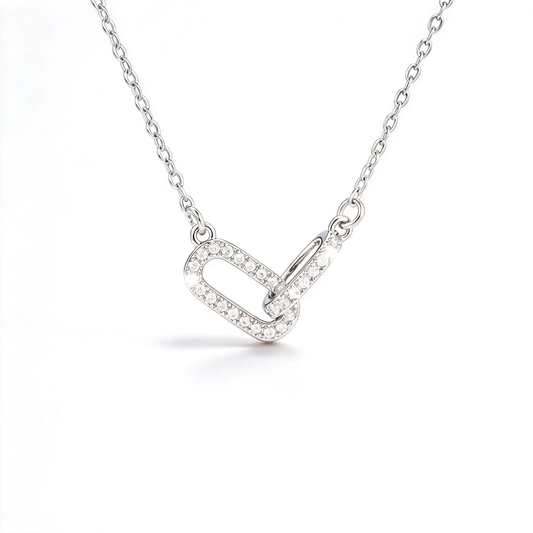 Silver-tone geometric link pendant necklace with interlocking shapes and sparkling pavé-style details.