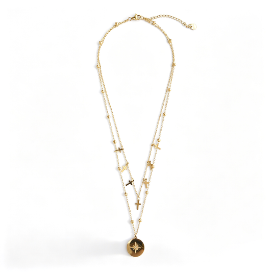 Full gold-tone layered cross necklace with starburst coin on white