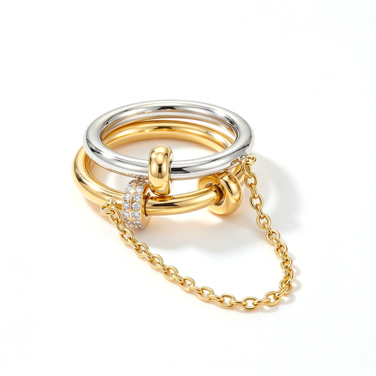 Angled view of a two-tone linked ring set with a draped chain and pink decorative accents