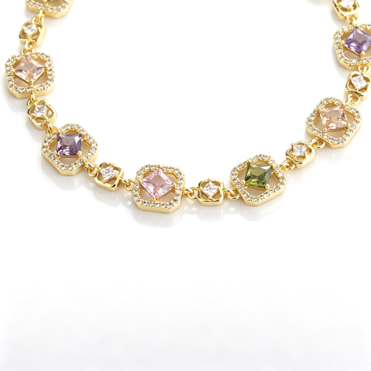 Detailed view of gold-tone bracelet links with pastel cushion-cut cubic zirconia and pavé halos.