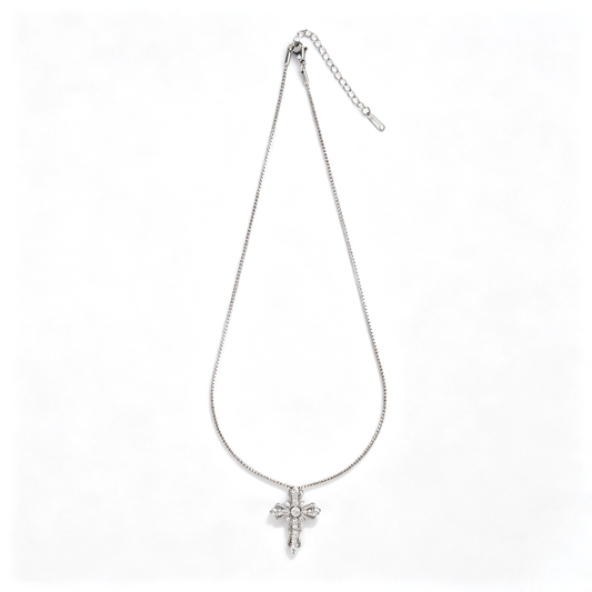 Full view of a silver-tone scalloped cross pendant necklace laid flat on a white background.