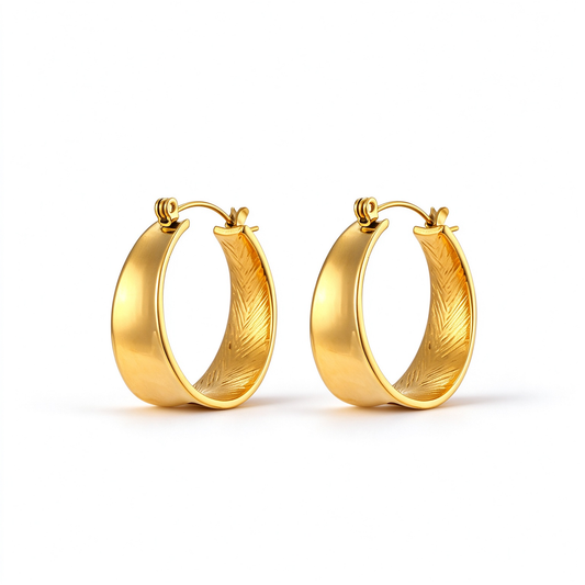 Gold-tone sculpted oval hoop earrings with smooth outer bands and textured inner detailing