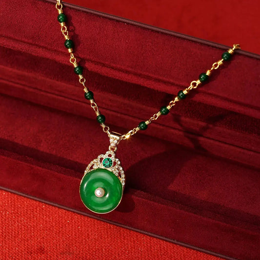 Flat lay of the vintage French Pingan disc pendant necklace on a premium crimson velvet jewelry box, highlighting the glowing emerald-green faux jade donut slider.