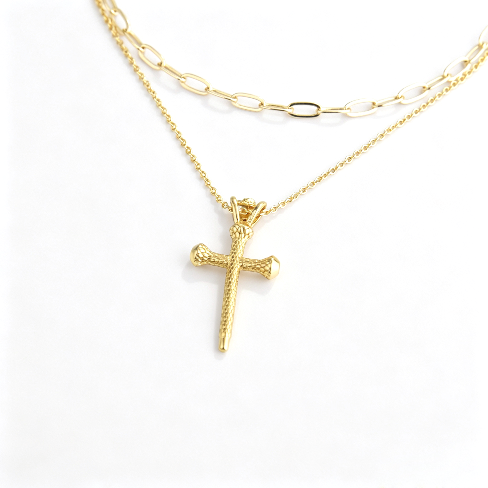 Model wearing 18k gold plated layered cross pendant necklace set with black V-neck top and blazer