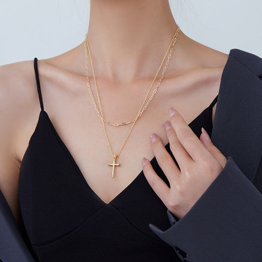 Model wearing 18k gold plated layered cross pendant necklace set with black V-neck top and blazer