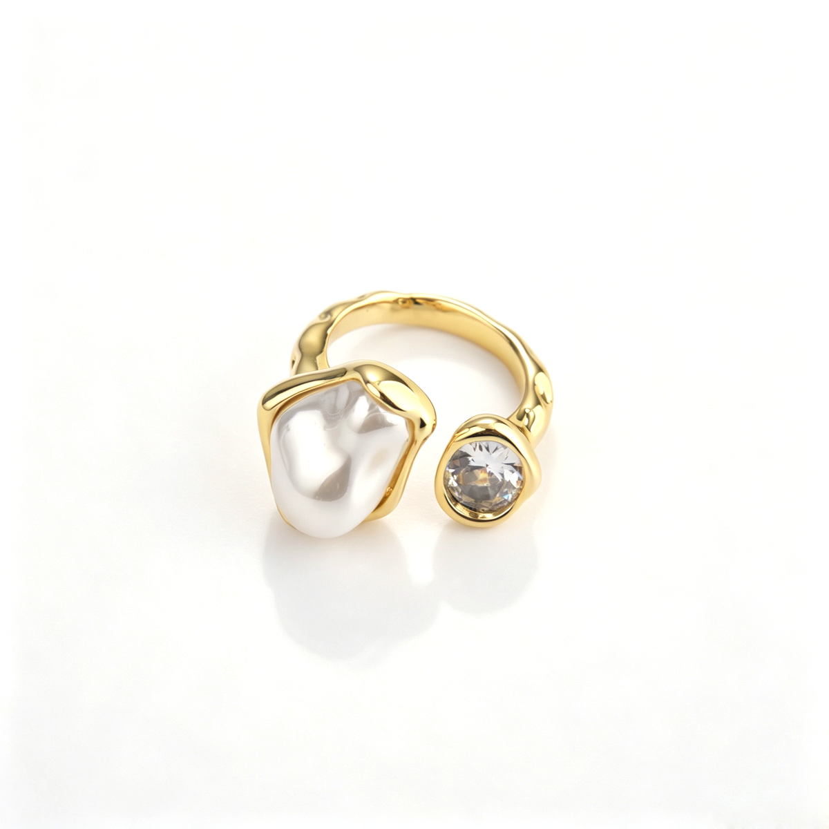 Frontal view of 18k gold-plated open ring featuring an irregular pearl and a brilliant cubic zirconia.