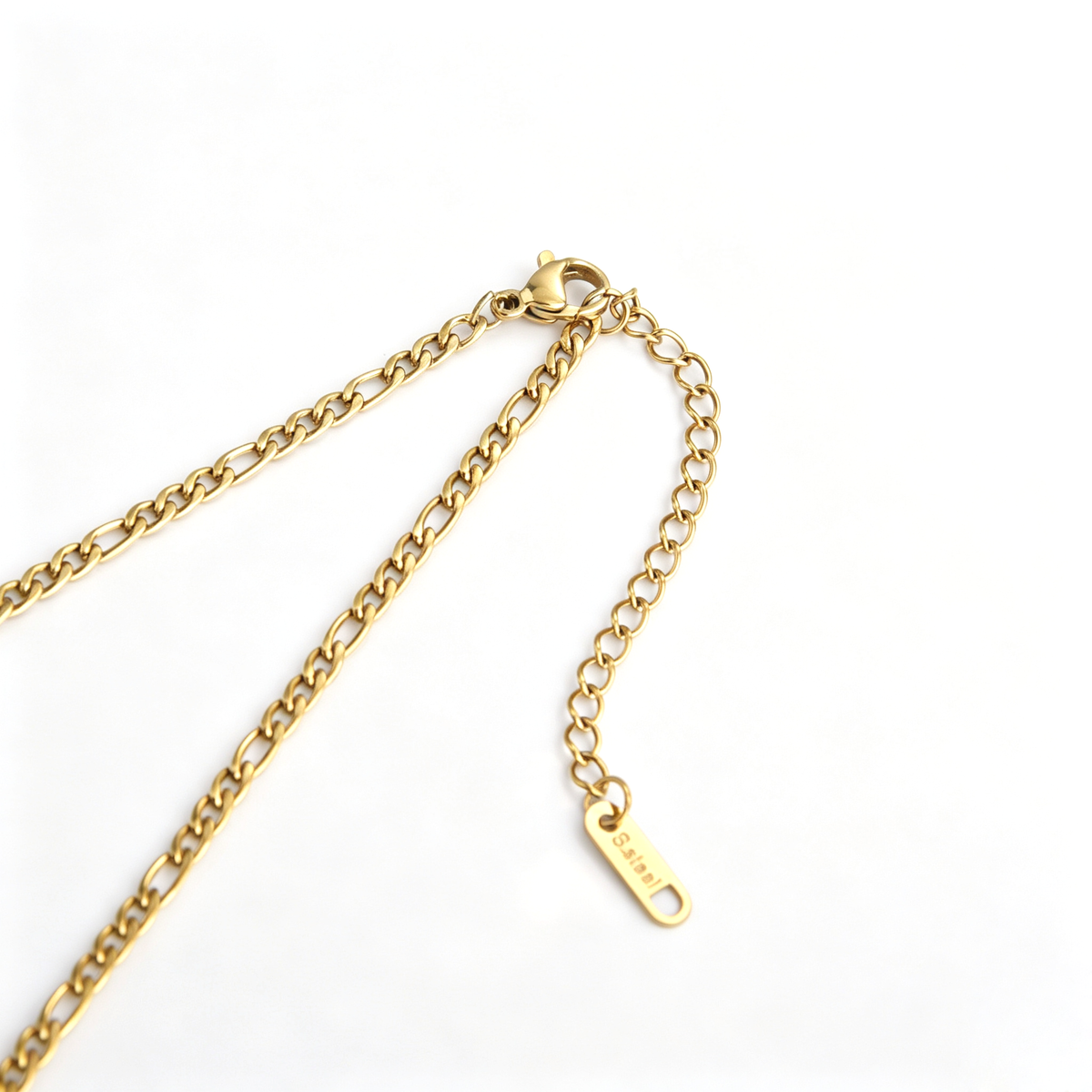 Close-up of lobster claw clasp, extension chain, and logo tag on an 18k gold plated Figaro chain necklace.