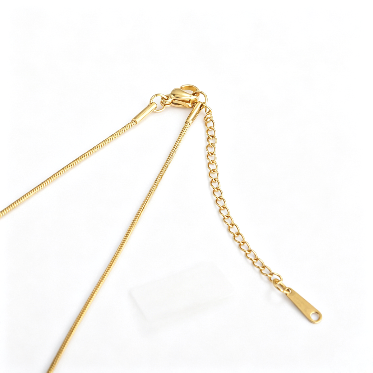 Close-up of the 18k gold-plated lobster clasp, delicate snake chain end, and adjustable extension link.