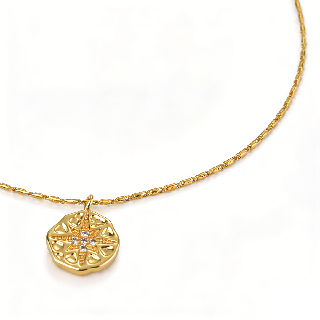 Close-up of 18k gold plated starburst medallion necklace with a 40+5cm adjustable chain.