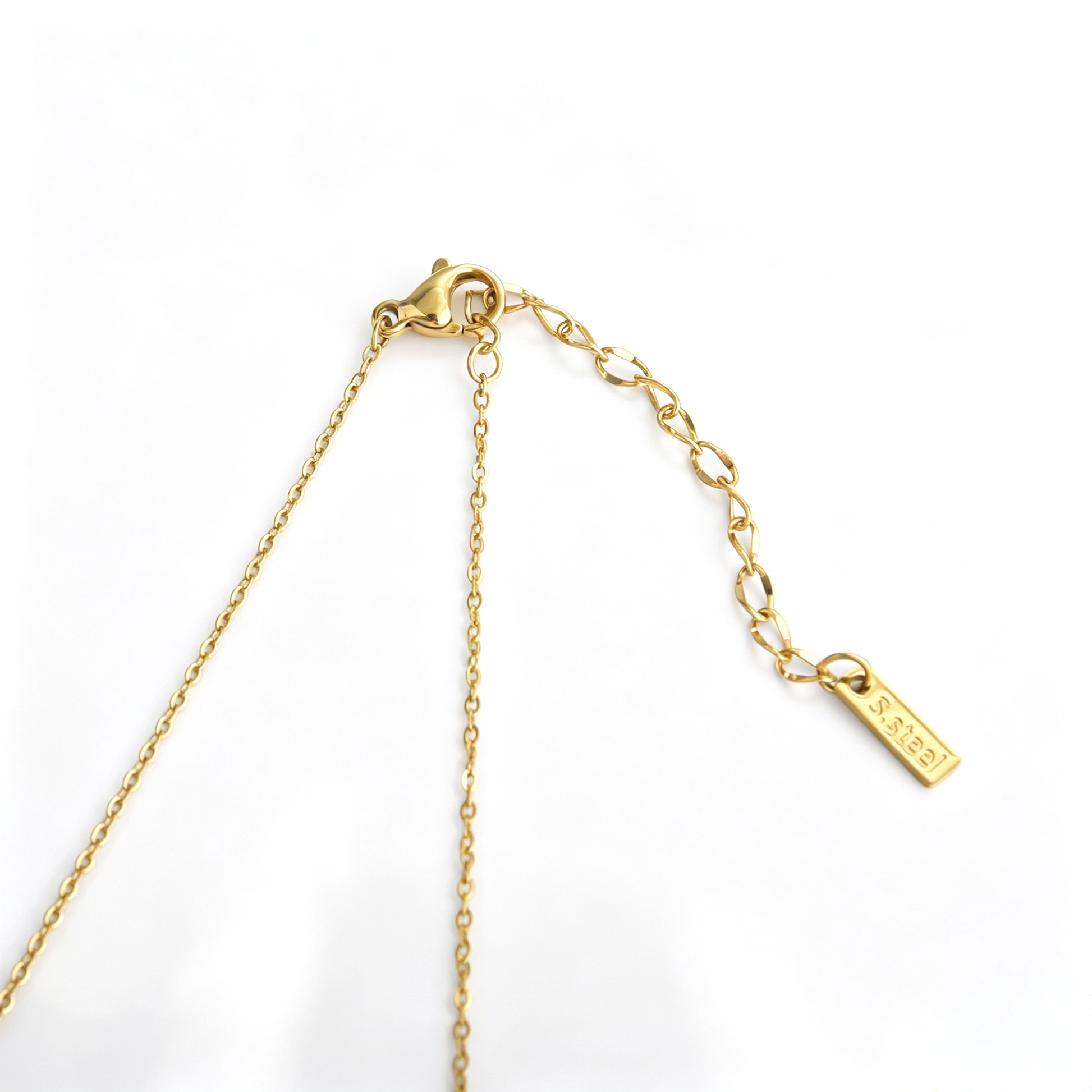 Macro detail of 0.7cm teardrop cubic zirconia stone set in smooth 18k gold plated bezel