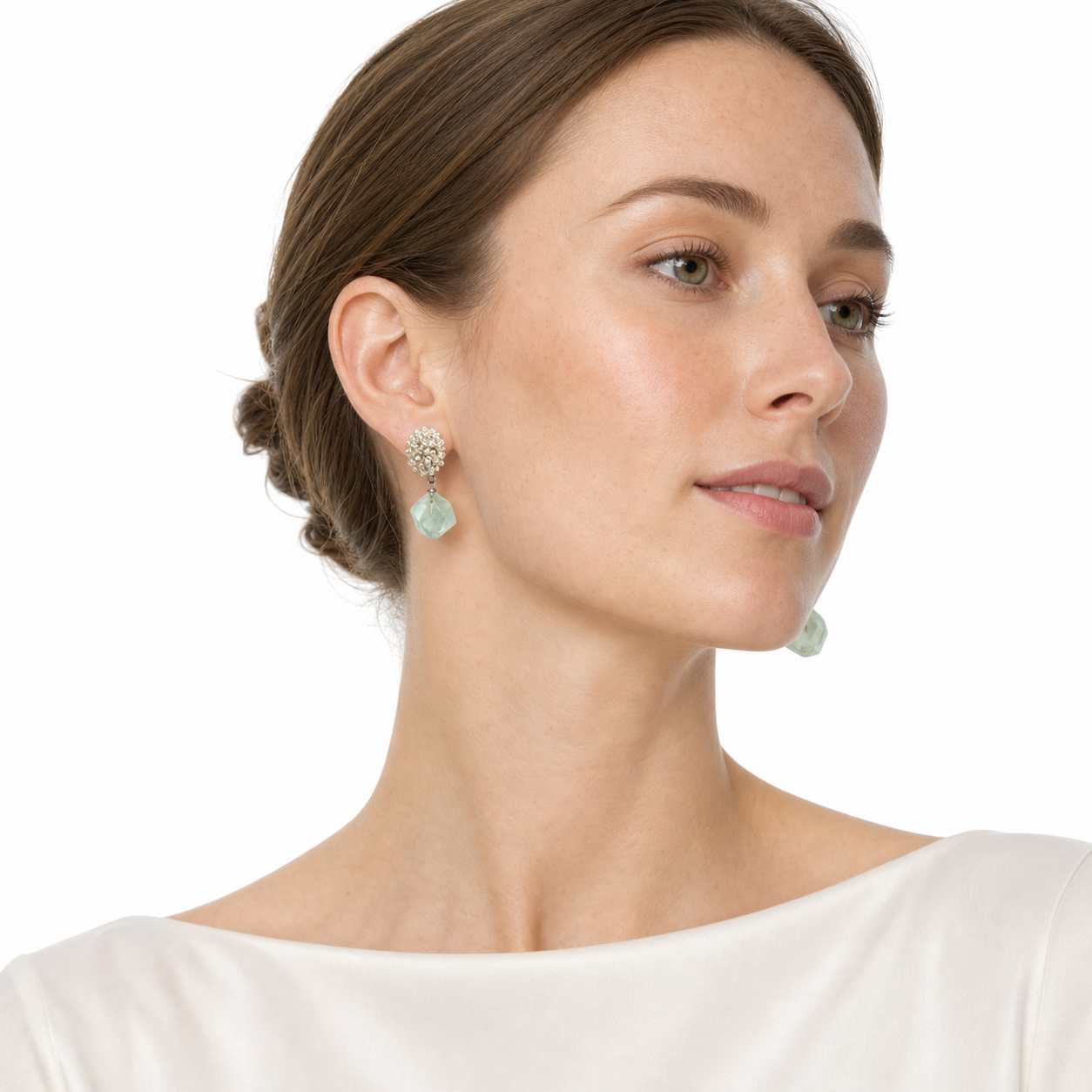 Western woman in a side-facing white-studio pose wearing pale green aventurine drop earrings with silver beaded tops.