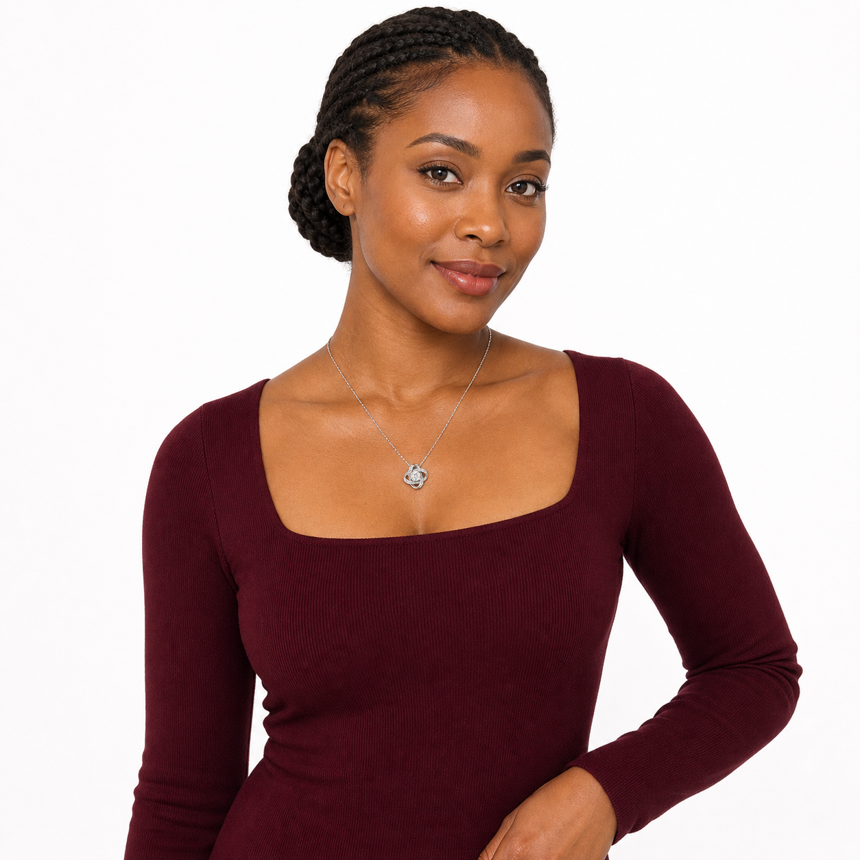 Black female model in a burgundy long-sleeve dress wearing an adjustable love knot CZ pendant necklace.