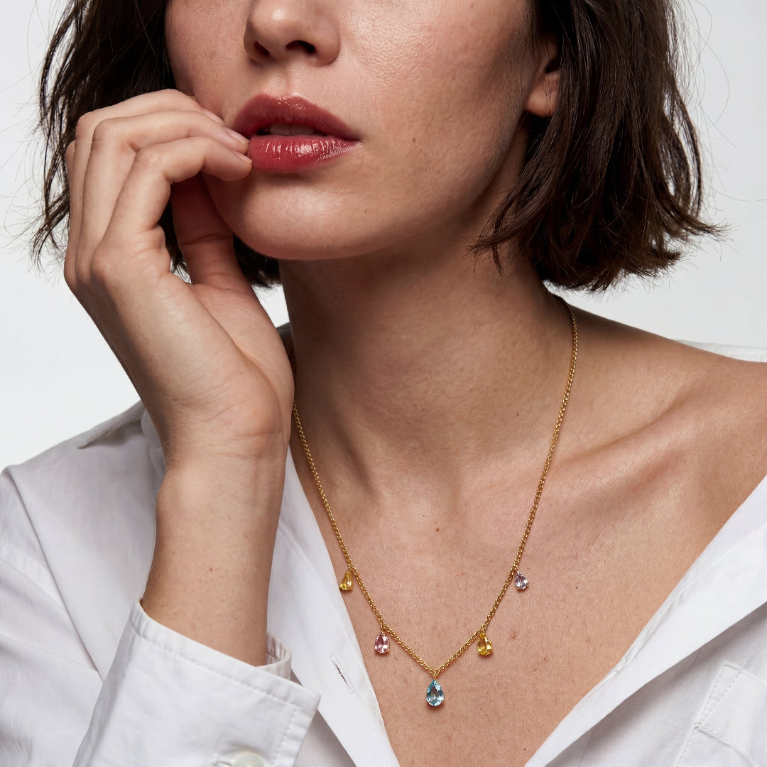 A model wearing Ever P. 18k gold plated teardrop necklace, styled as an elegant clavicle chain with a white shirt.