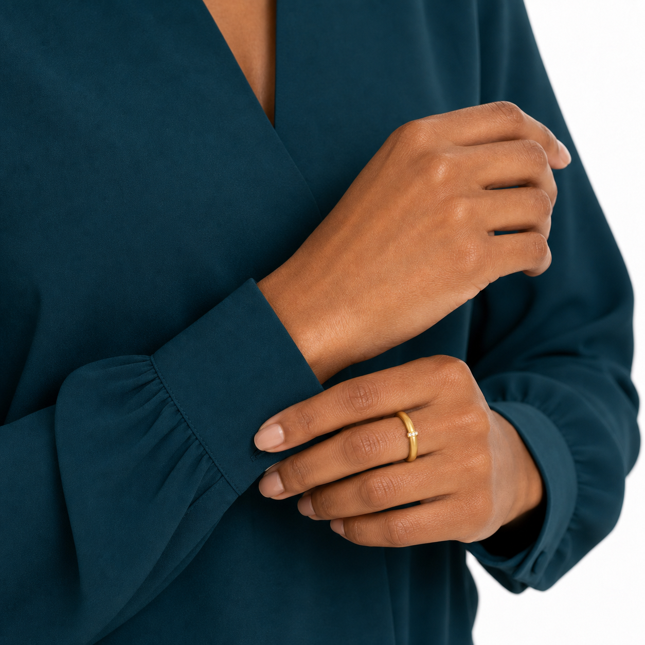 Black female model adjusting her teal cuff while wearing a matte gold-tone statement ring.