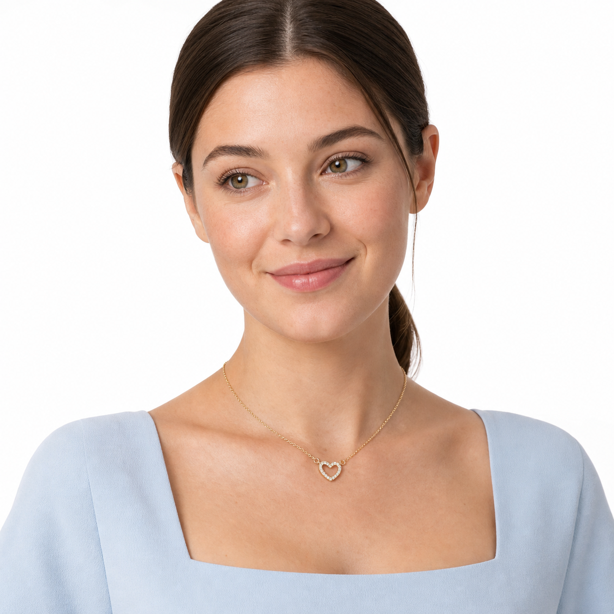 Young woman in a powder-blue top wearing a gold-tone micro-pavé cubic zirconia open heart necklace.