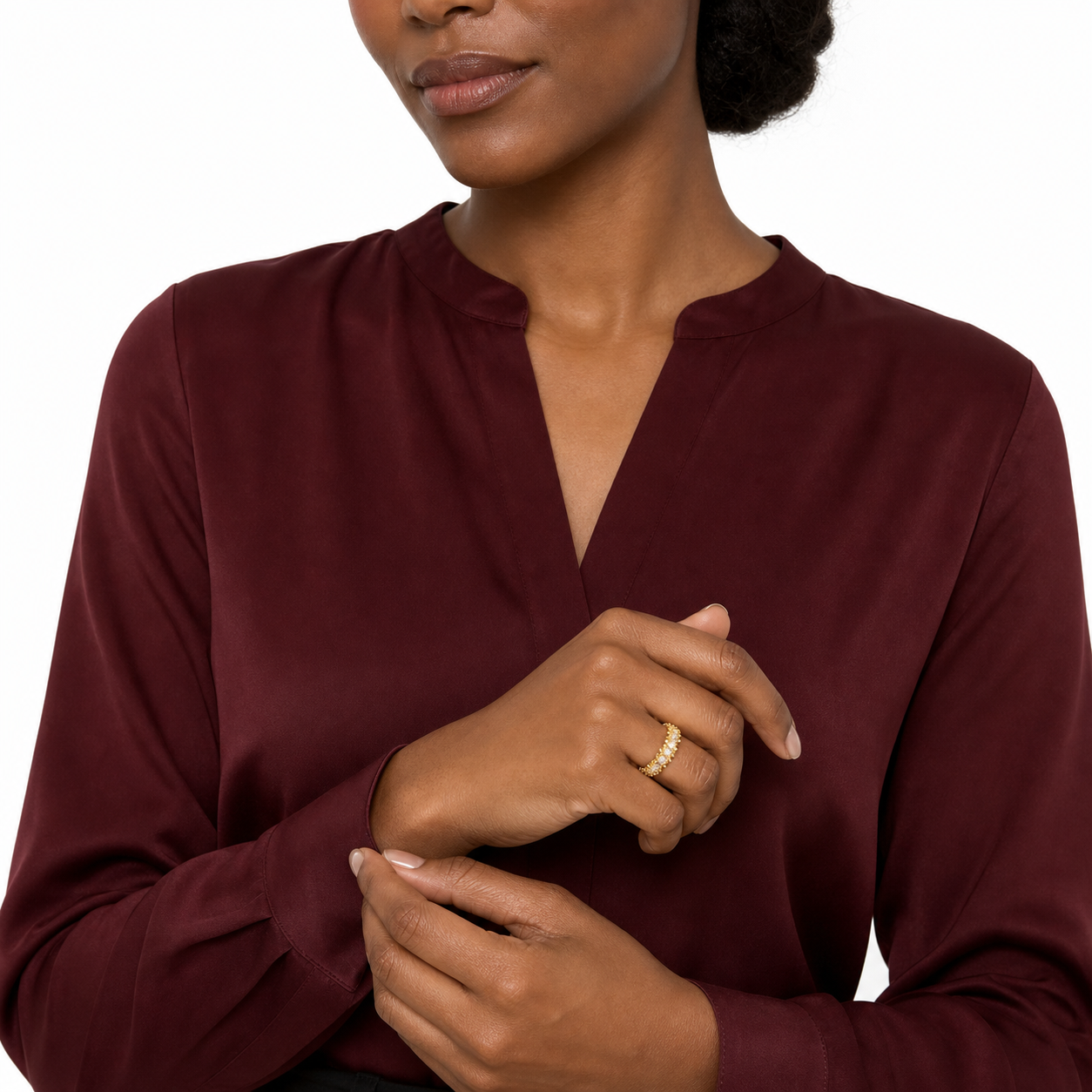 Cropped studio portrait showing a gold-tone open CZ pavé ring styled with a burgundy blouse.