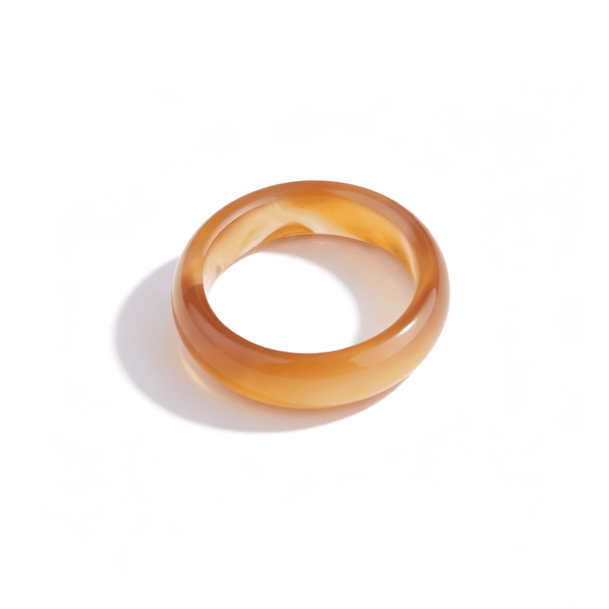 Side view of a slim amber chalcedony ring, showcasing its minimalist natural stone design and warm golden glow.