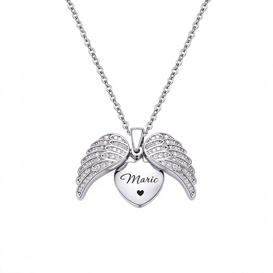 Silver-tone heart pendant framed by decorative angel wings with engraved lettering.