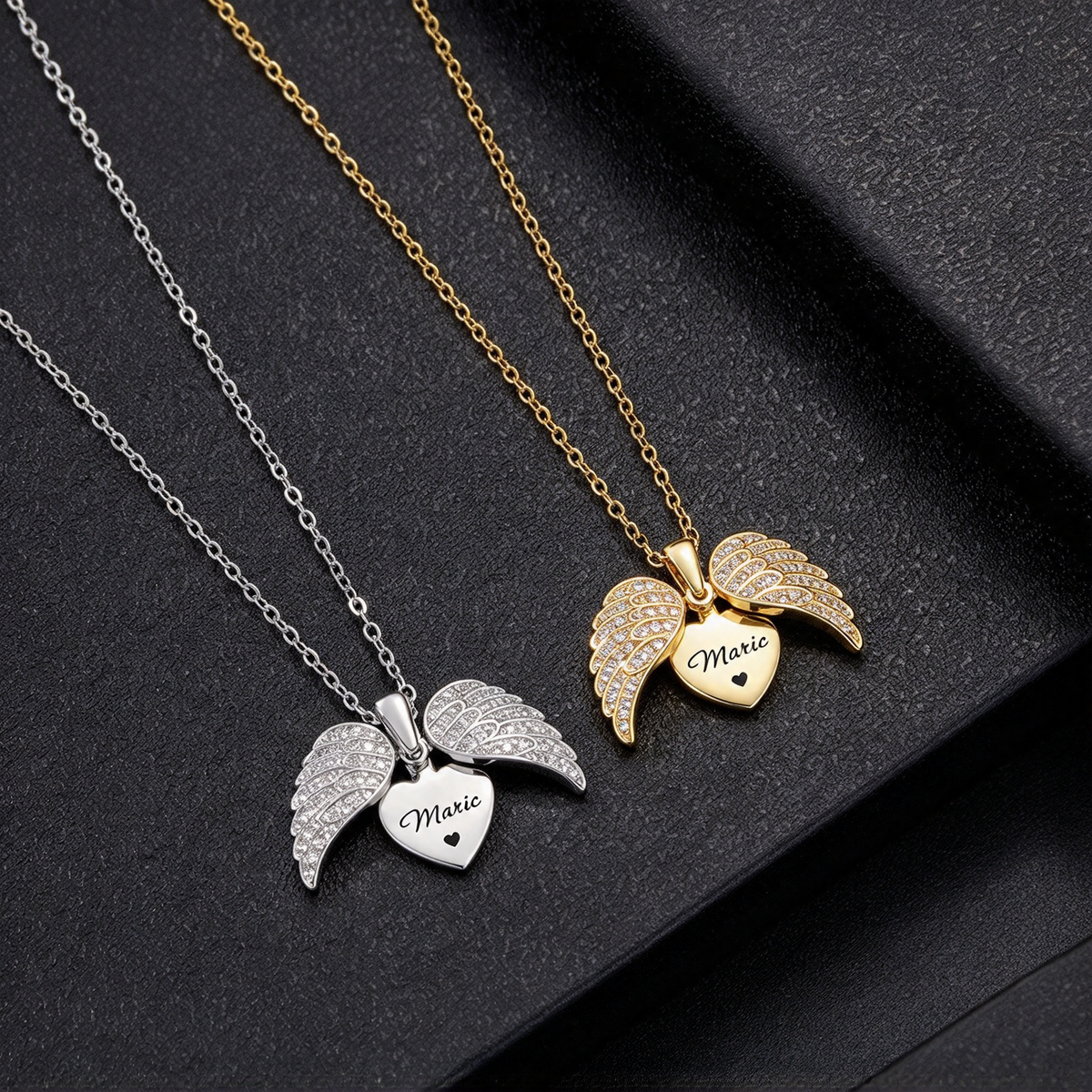 Gold-tone and silver-tone angel wings heart necklaces displayed side by side on a dark background.