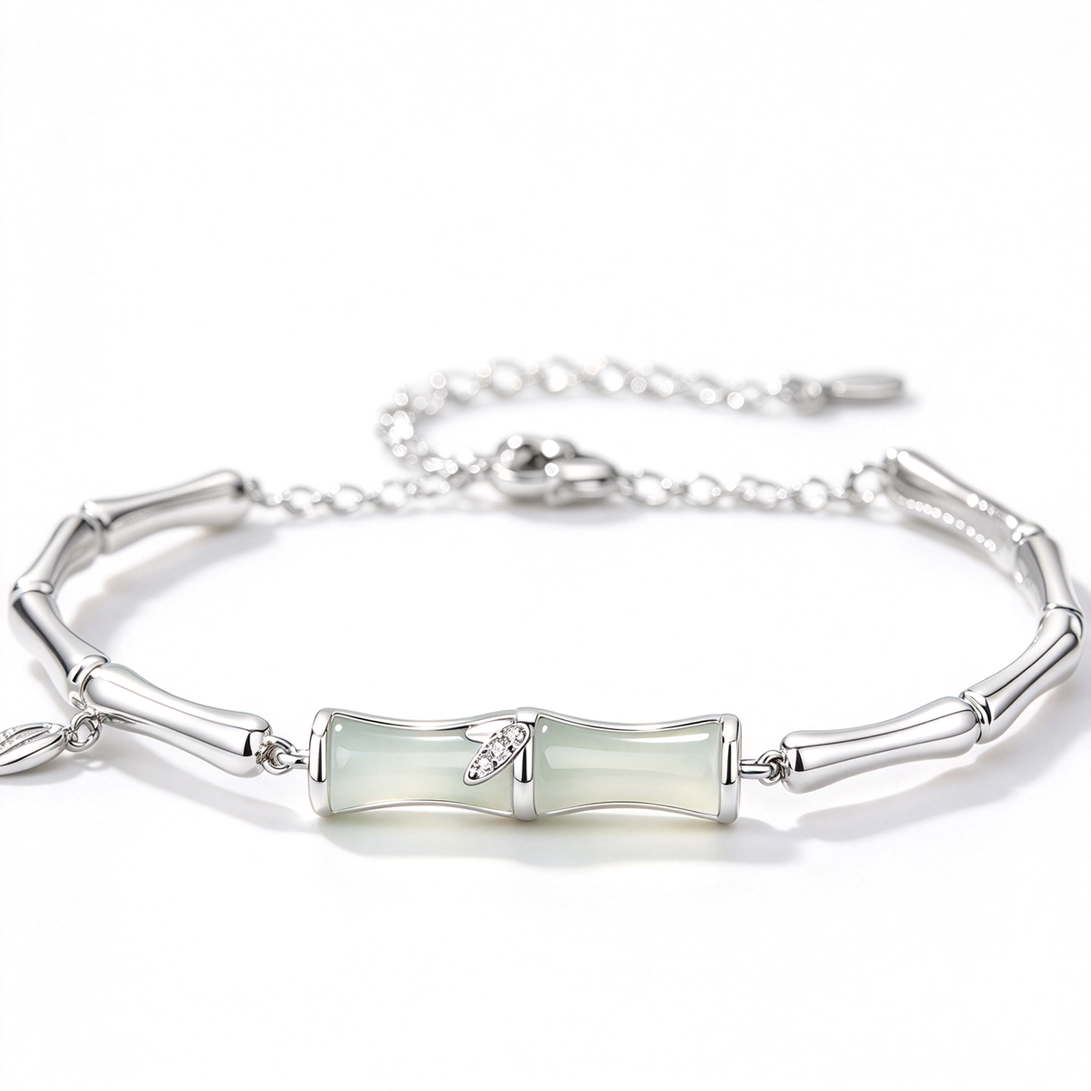 Silver-tone bracelet featuring pale green center segments, a decorative leaf accent, and a linked chain.