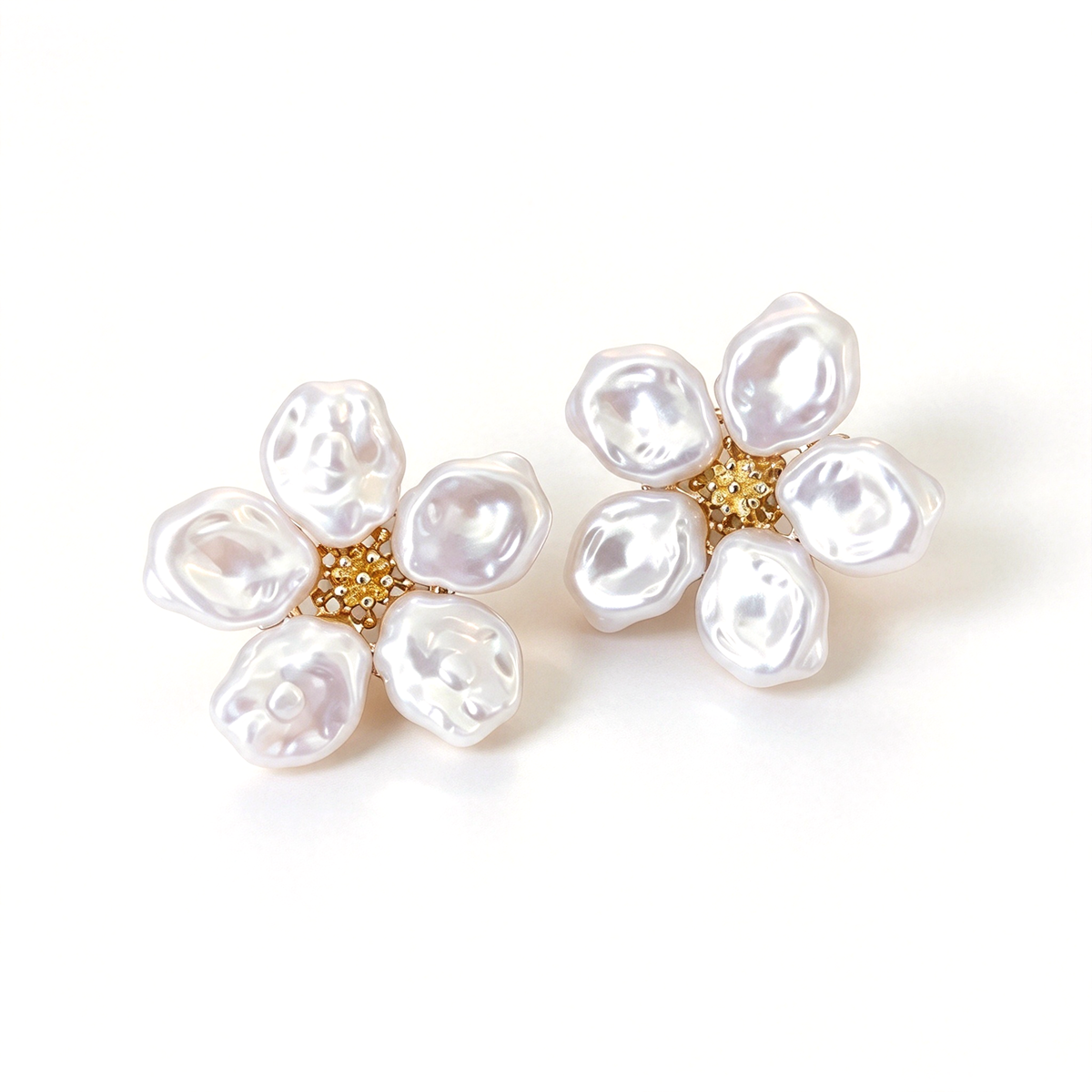 Baroque flower stud earrings with sculptural white petals and a textured gold-tone center on a white background.