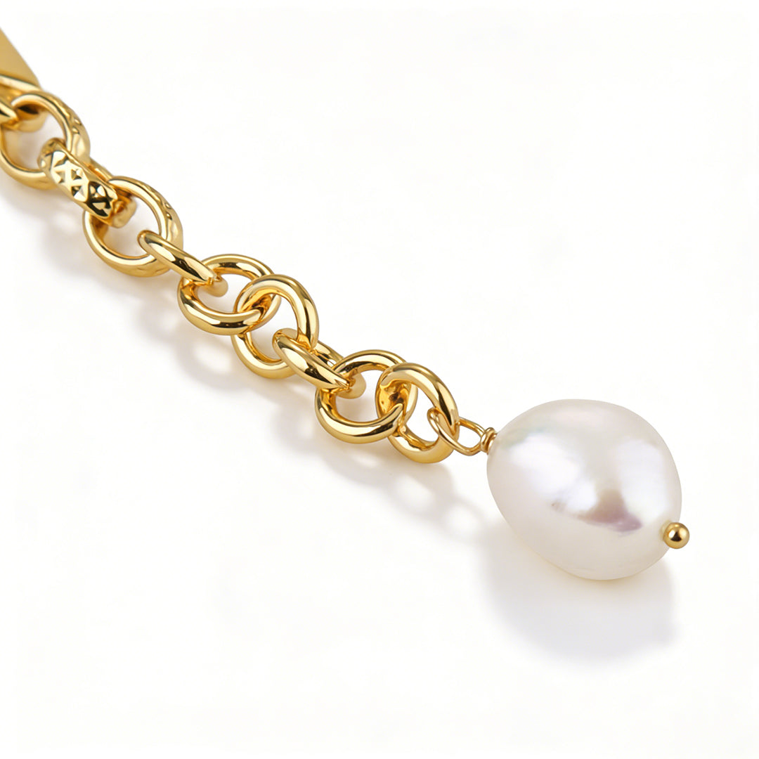 Side view showing the unique organic shape of the baroque pearl on a gold chain.