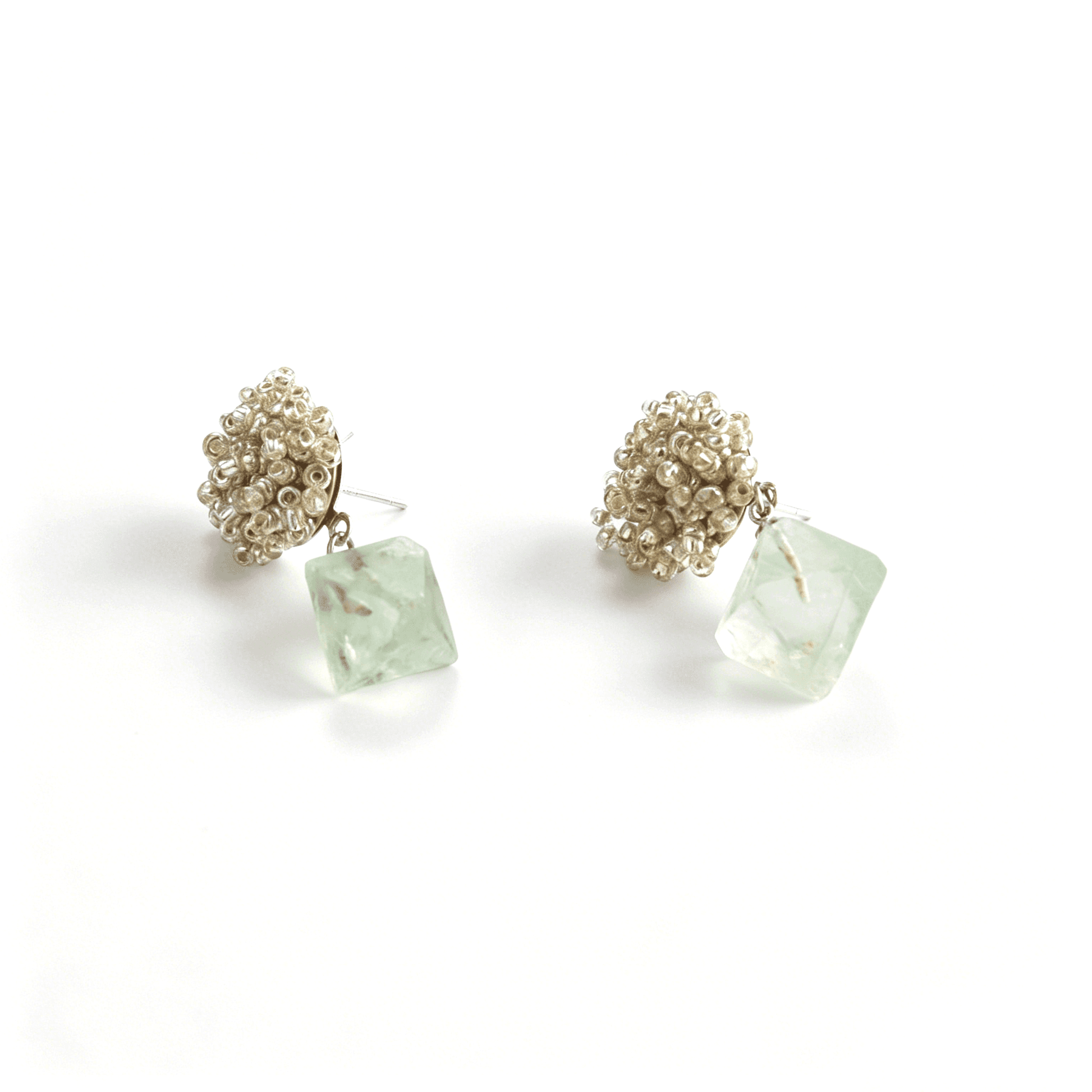 Angled view highlighting the hand-woven metallic seed bead clusters and translucent faceted green aventurine drops on titanium posts.