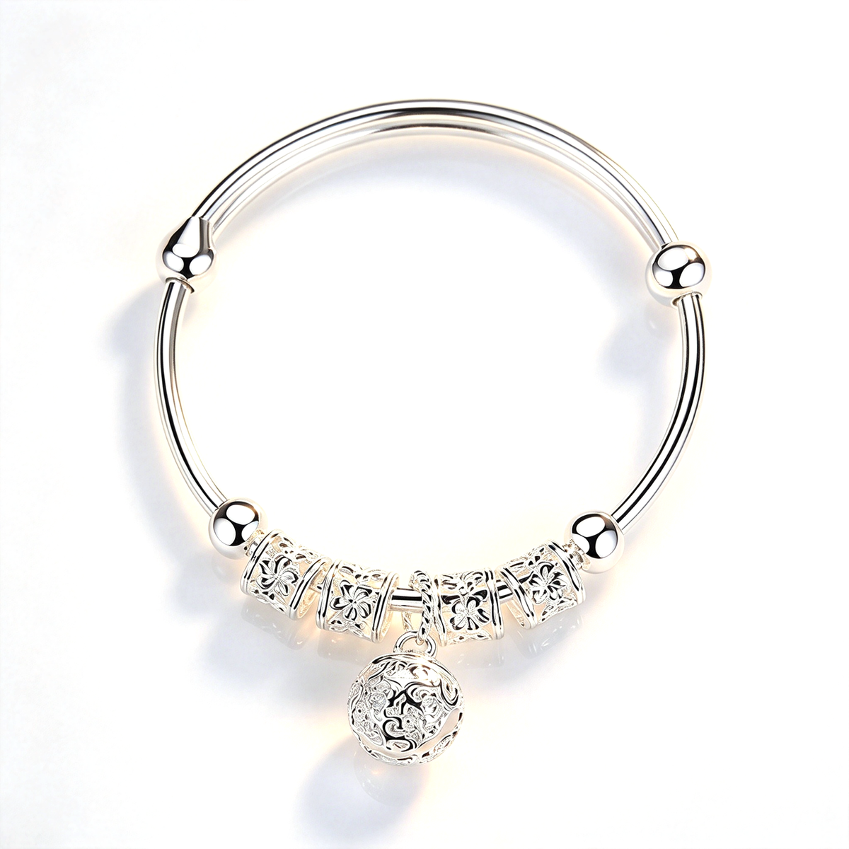 Bell charm bangle bracelet with ornate decorative details and a dangling round charm, shown against a white background