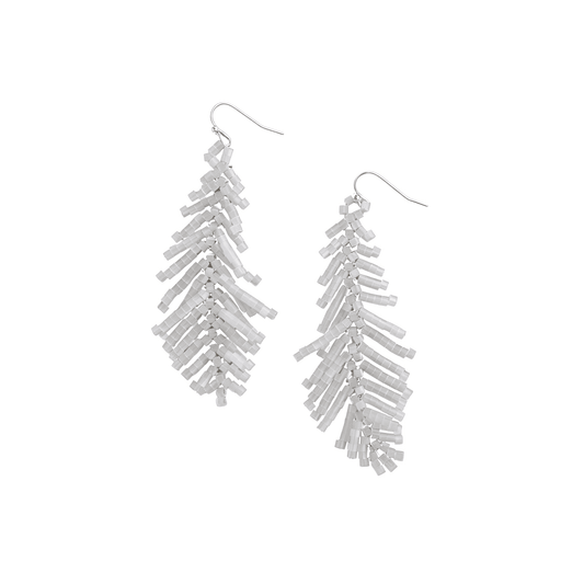 Studio profile of Ever P. handcrafted white seed bead palm leaf fringe earrings hanging from sleek silver-plated metal hooks.