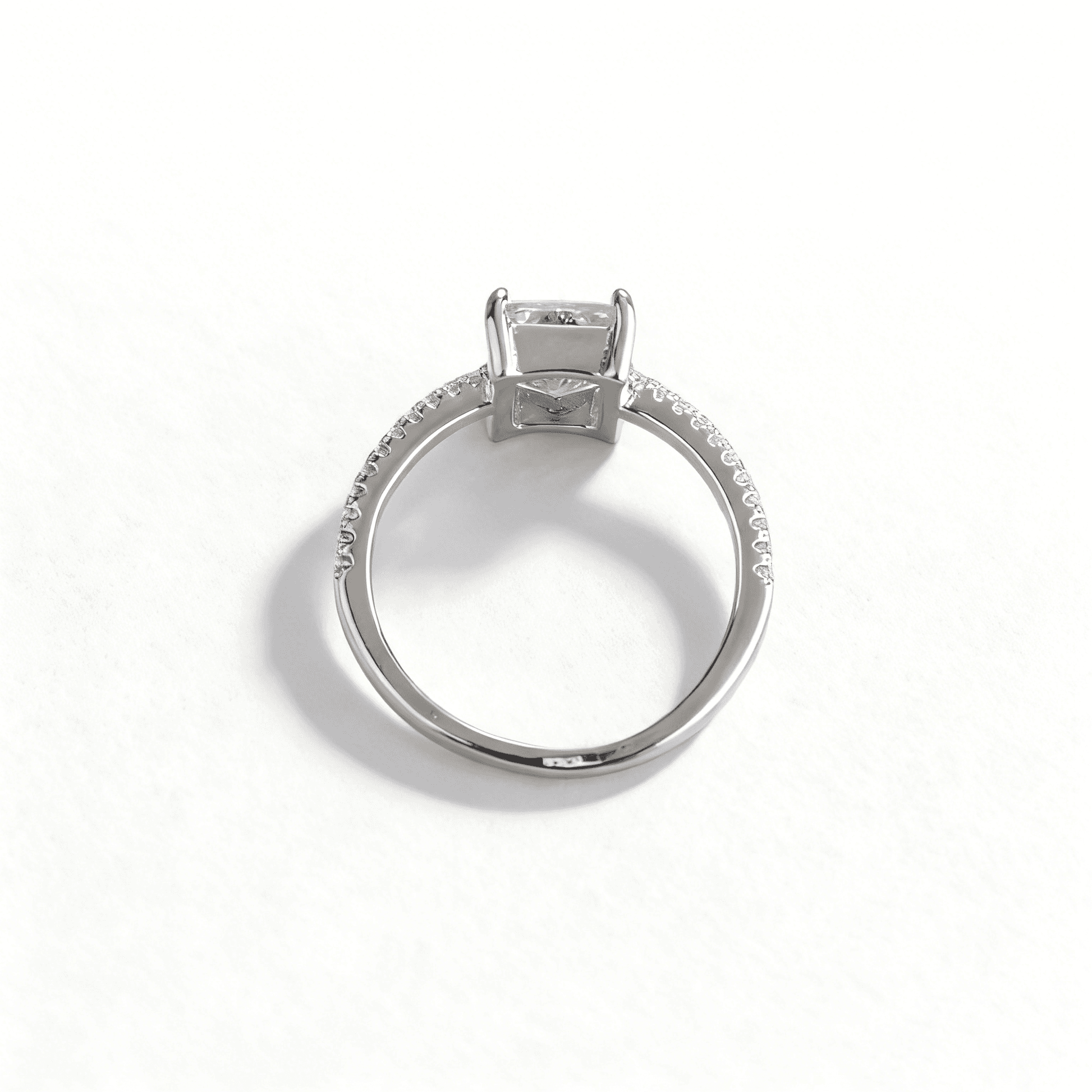 Detailed angled view of brilliant emerald-cut CZ solitaire ring, alternative view showcasing geometric facets.