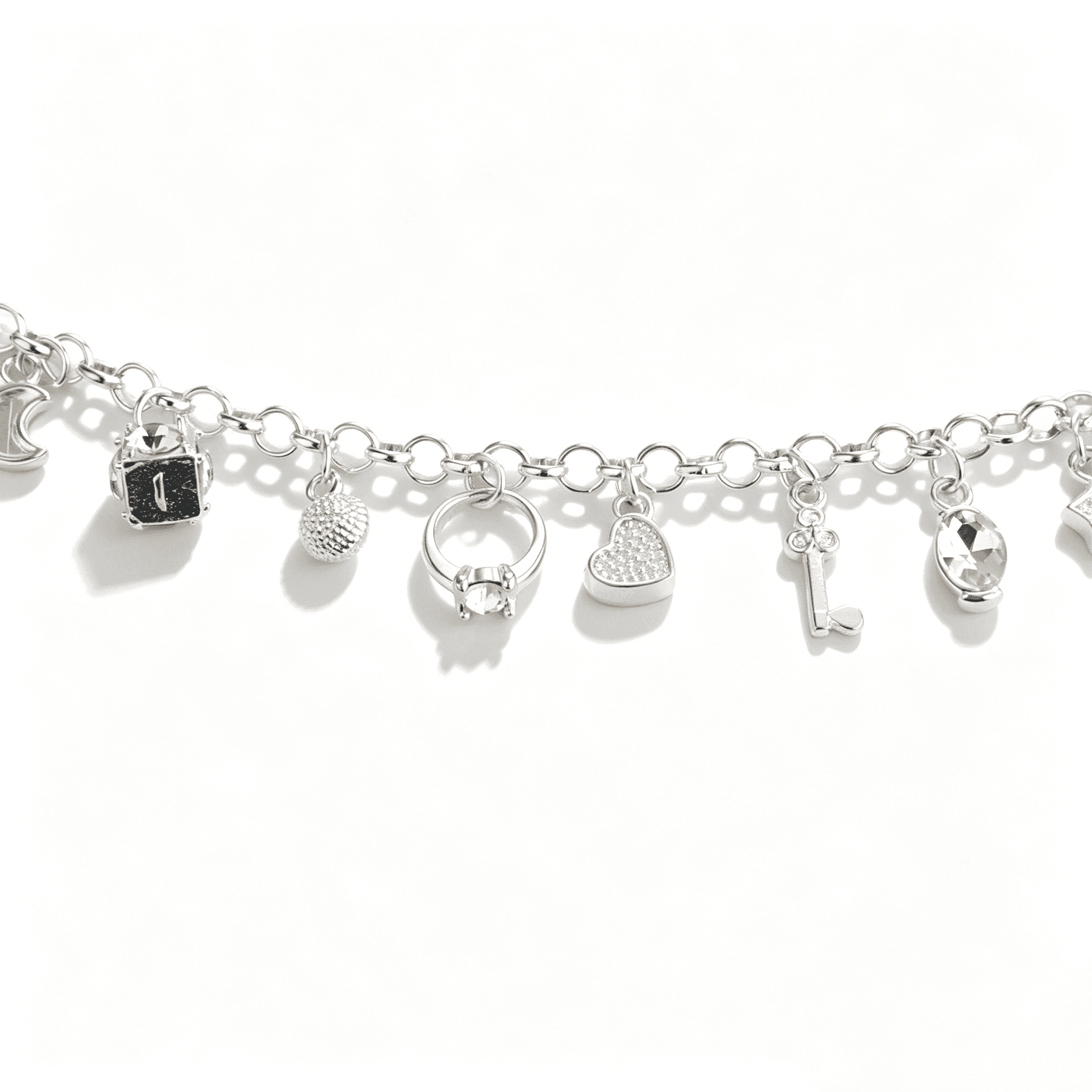 Focus on eclectic pendants of a charm bracelet for women, including a 3D dice, a textured ball, and a solitary ring.