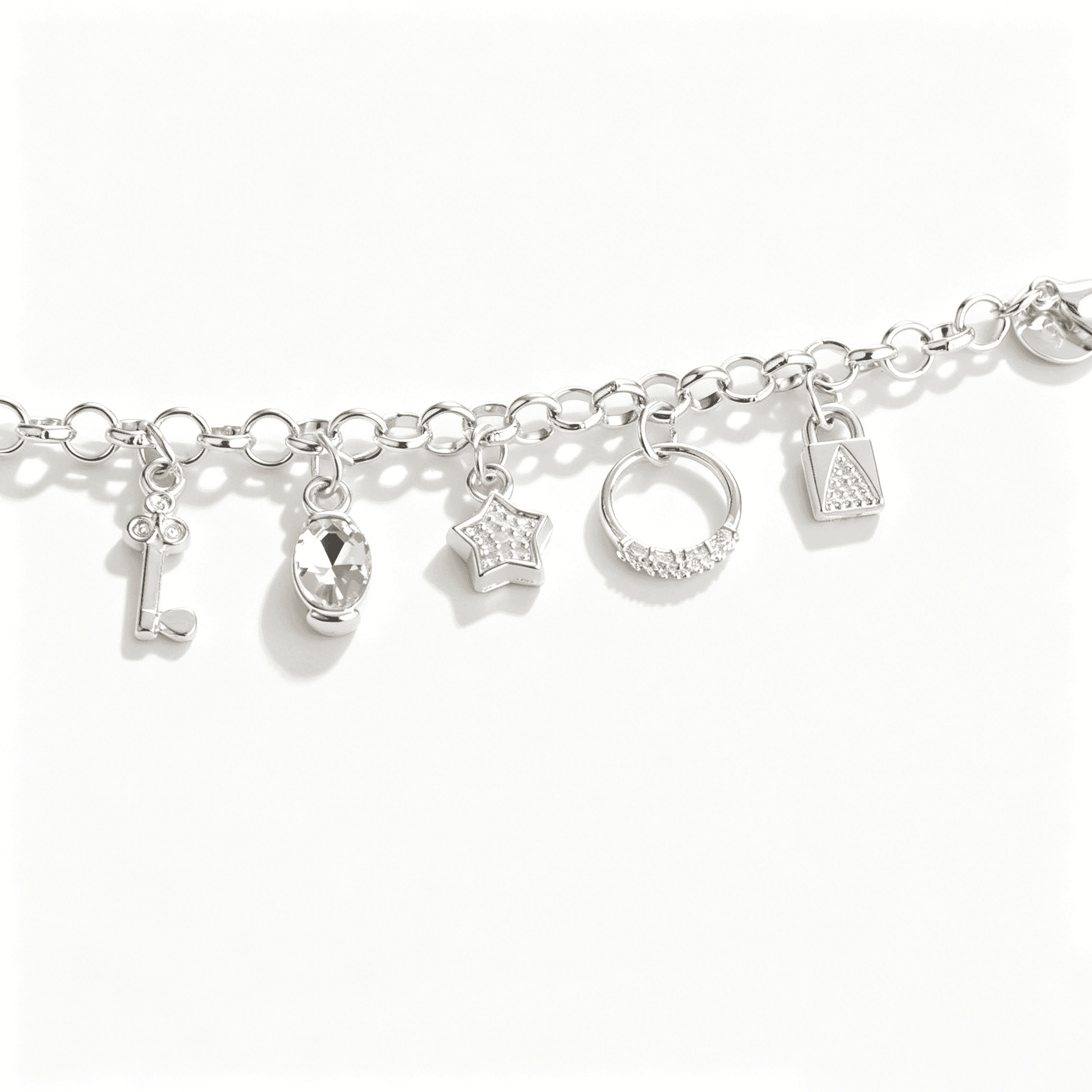 Detailed shot of a charm bracelet for women showcasing sterling silver key, star, and lock pendants with zircon accents.