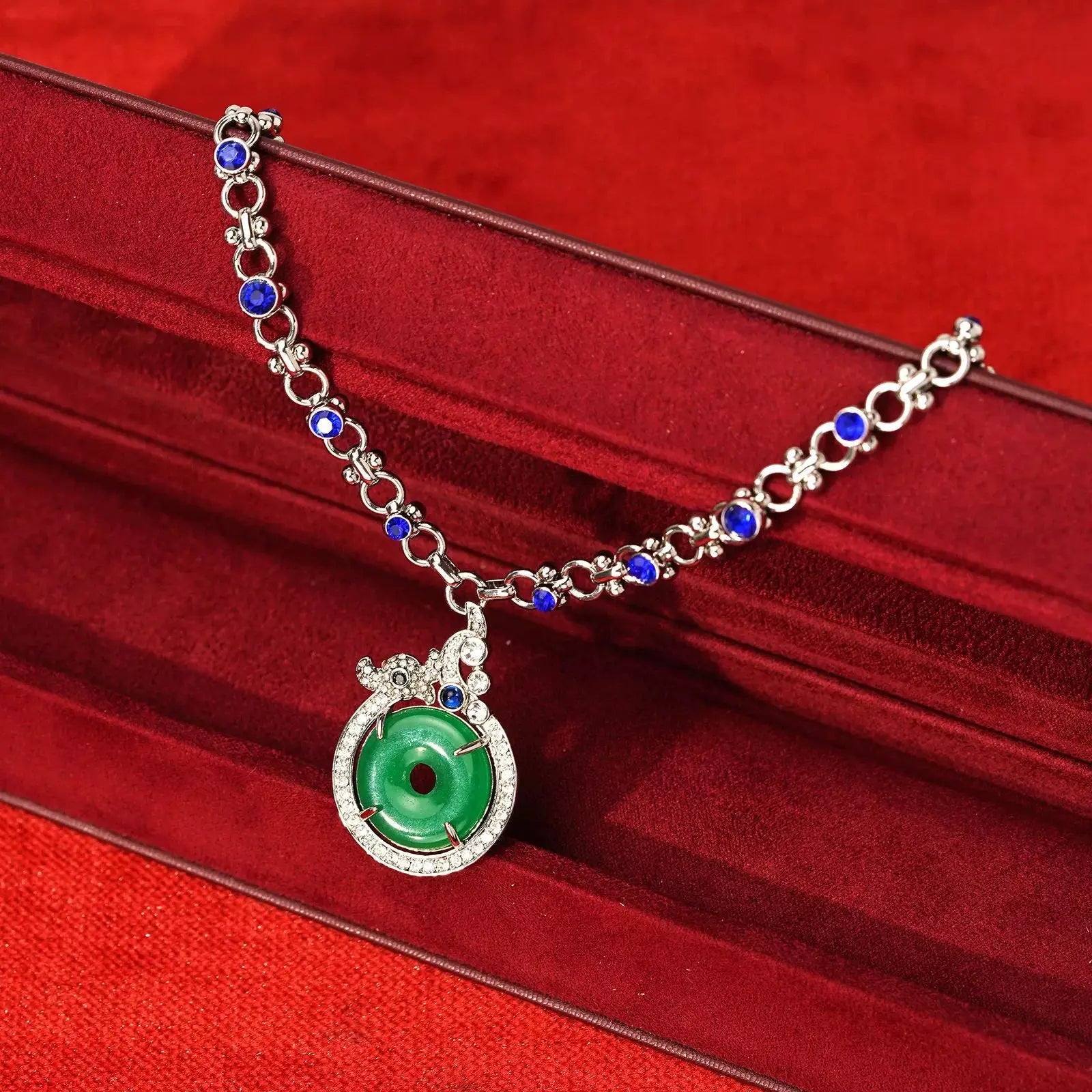 Close-up of the platinum-plated crown casing micro-paved with CZ crystals cradling the translucent green crystal donut charm.