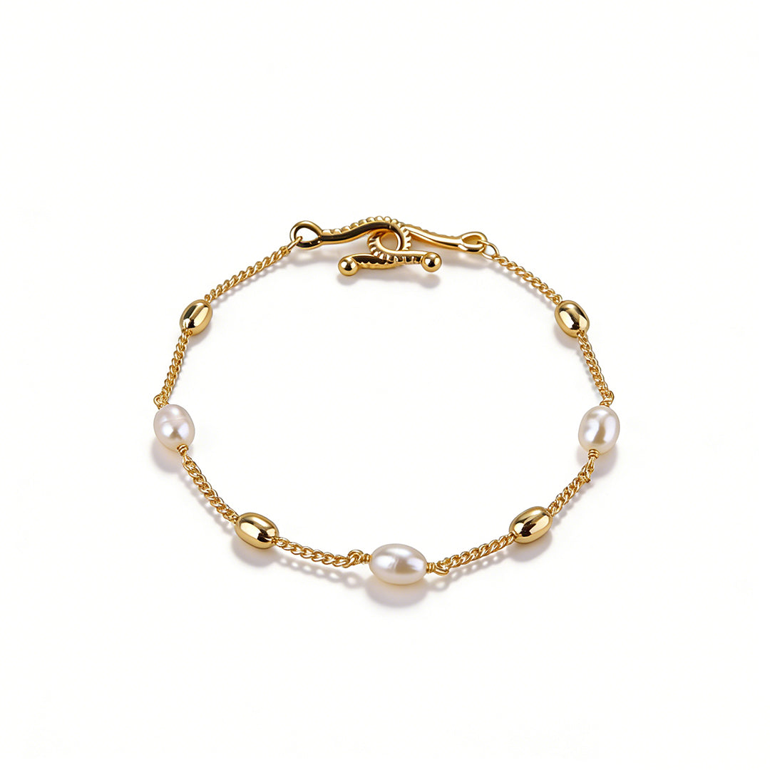 Detailed view of the chunky rectangular and circular link intersection on a gold bracelet.