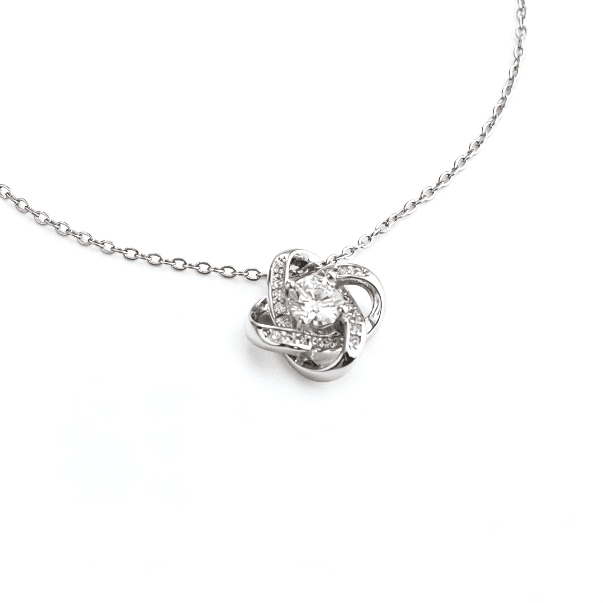 Angled macro profile showcasing the delicate pavé cubic zirconia gemstones set into the silver-plated knot.