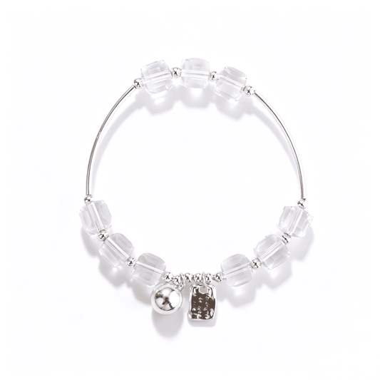 Top view of a 17 cm adjustable bracelet with clear faceted cube beads, silver-tone curved tubes, round spacers, and two charms.