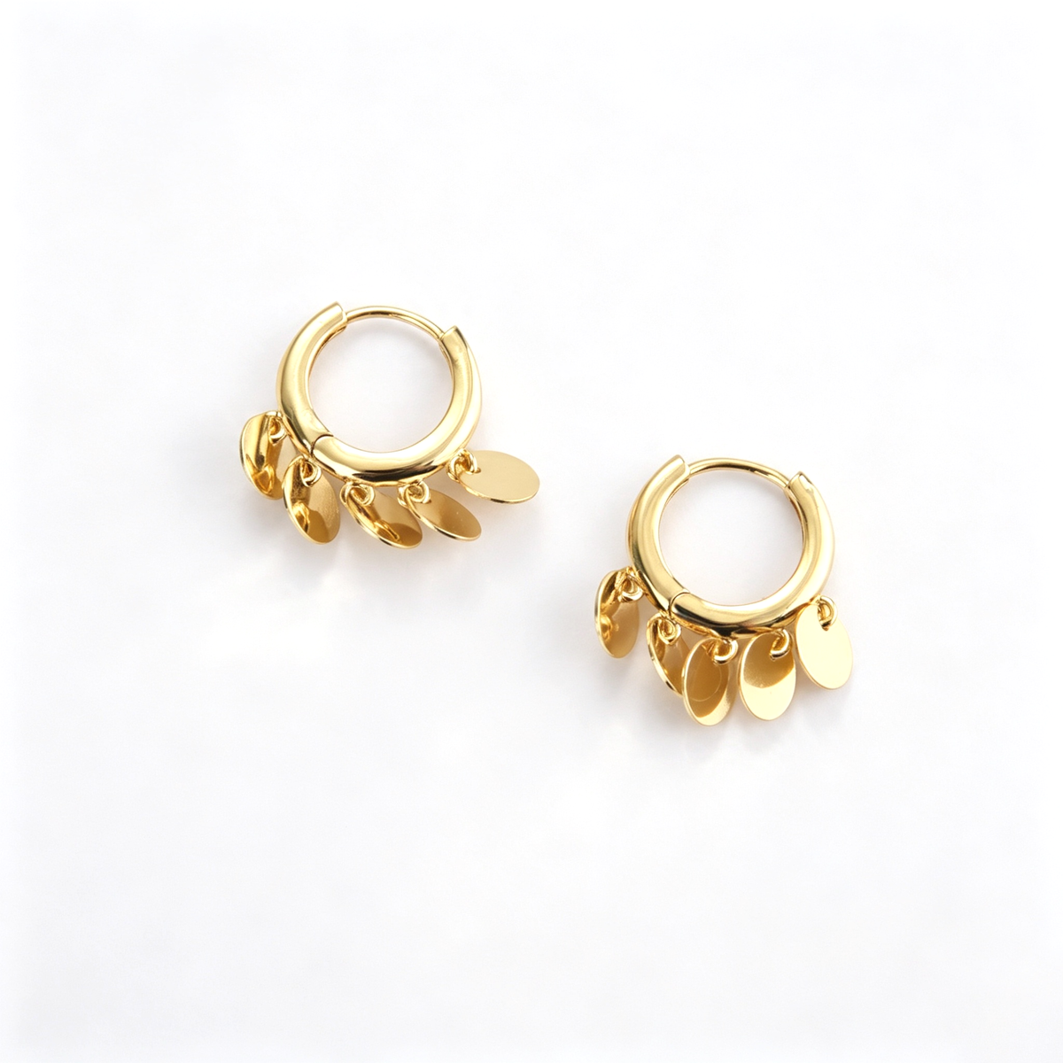 Close-up view of the round hoops and overlapping dangling disc charms
