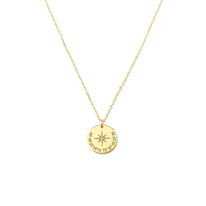 Gold-tone compass star pendant necklace with coordinate-style markings on a white background.