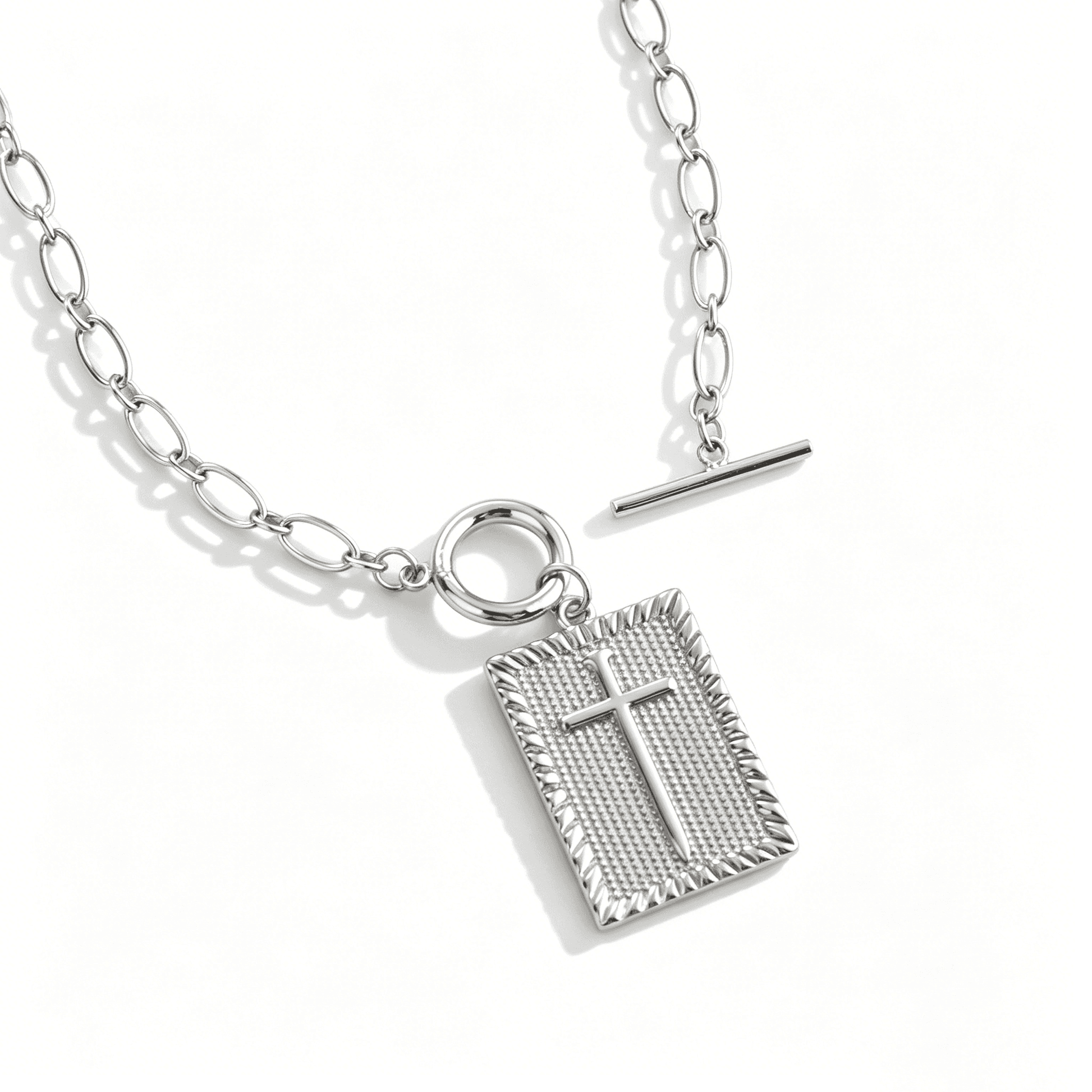 Overhead view of a silver cross necklace for women featuring a 3D geometric cube pendant.