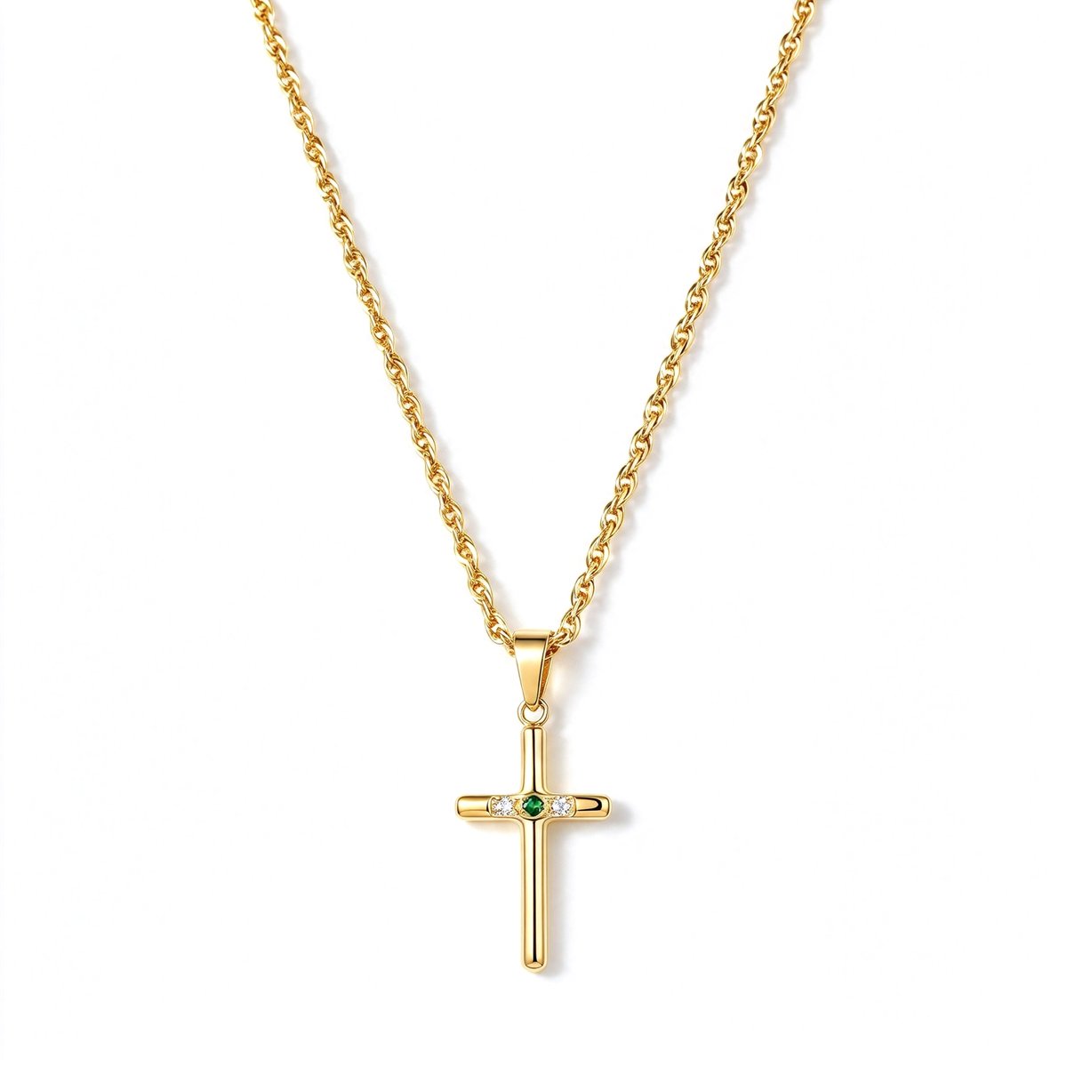 Gold-tone cross pendant necklace with a small green center accent and clear decorative details on a white background.